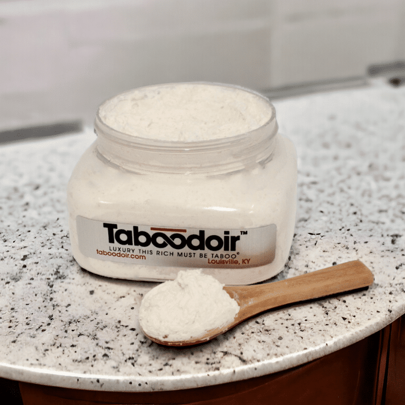 Wooden spoon next to an open jar of Taboodoir Intoxicating Hand & Body Souffle Scrub