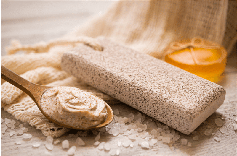 pumice stone with spoon of scrub