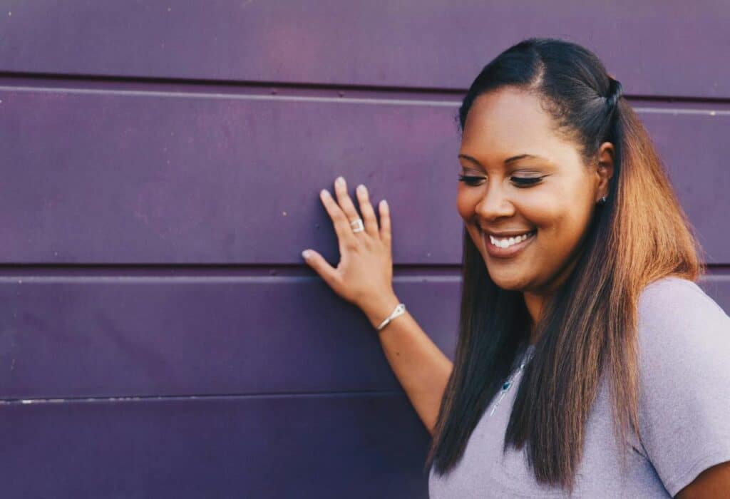 woman-standing-touching-gray-wall-wearing-gray-shirt