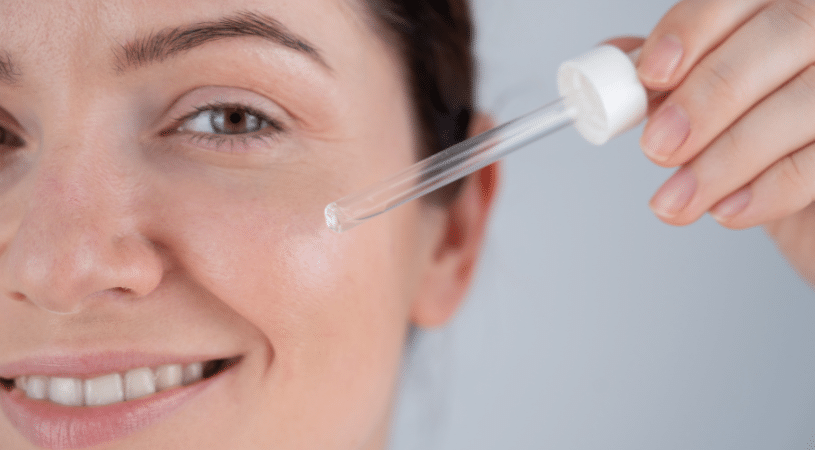 Woman applying serum to face