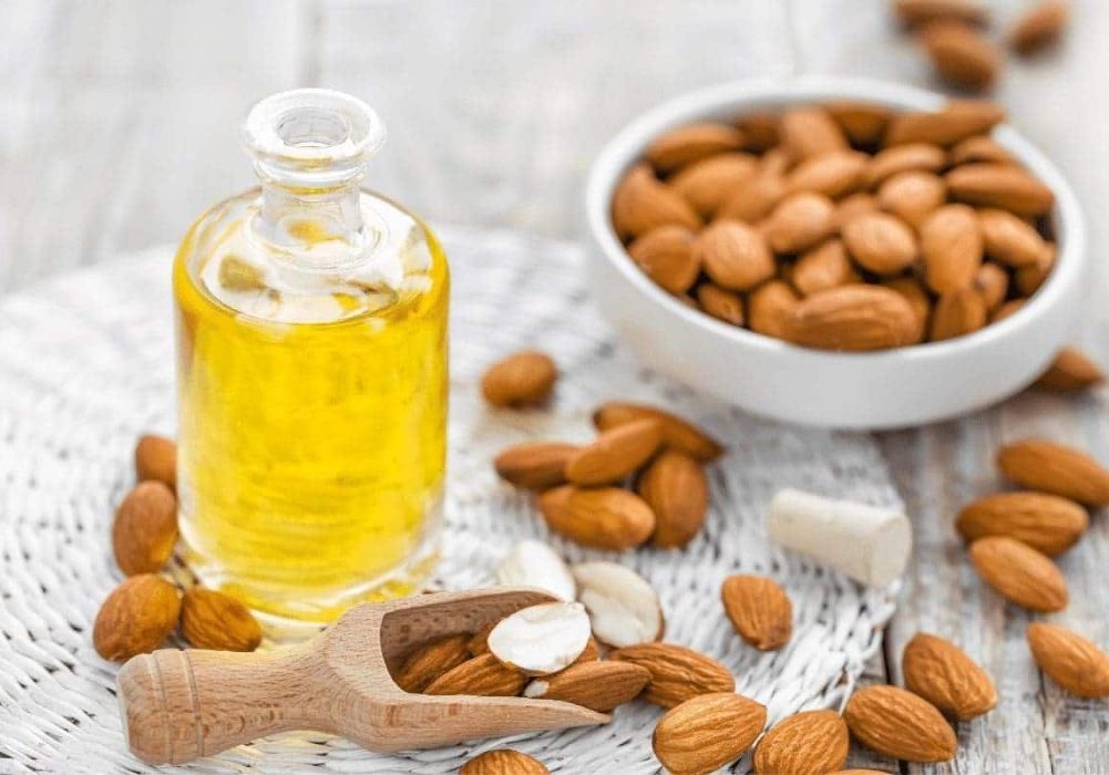 Almonds in a bowl and a bottle of oil