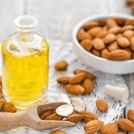 Almonds in a bowl and a bottle of oil