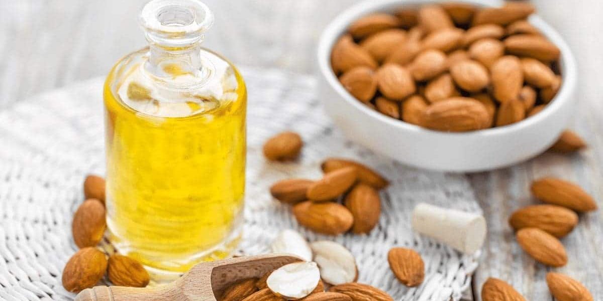 Almonds in a bowl and a bottle of oil